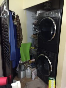 Laundry before: hardware, craft supplies, laundry products, all crowded in behind 2 large room separators.